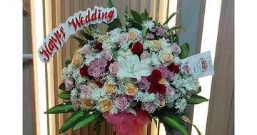 Karangan bunga pernikahan gaya floral penuh warna cerah